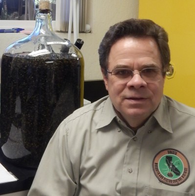 The water jug near John Albright's right shoulder contains nearly 70,000 yellowjackets preserved in alcohol.  These were caught in Enterprise Park in Redding during the yellowjacket control experiment in the summer of 1999.