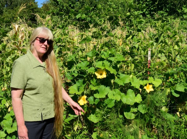 POP Executive Director Melinda Brown stands before squash, beans, corn and fruit trees in the People of Progress Community Garden. She said those who farm plots here donate fresh produce to the non-profit's food bank. Photo by Richard DuPertuis.