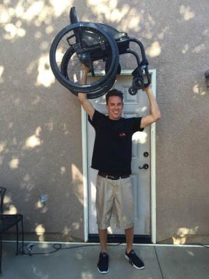 Kyle Stewart loves a challenge, which might explain why he lifted his wheelchair over his head for this photo. 