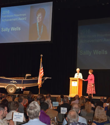 Francie Sullivan presents a philanthrophy award to Sally Wells.