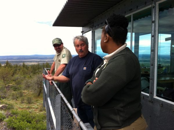 Blue Mountain Lookout worker Gary Neal, center, describes the lay of the land to Gary Sandusky, left, and Danelle Harrison.